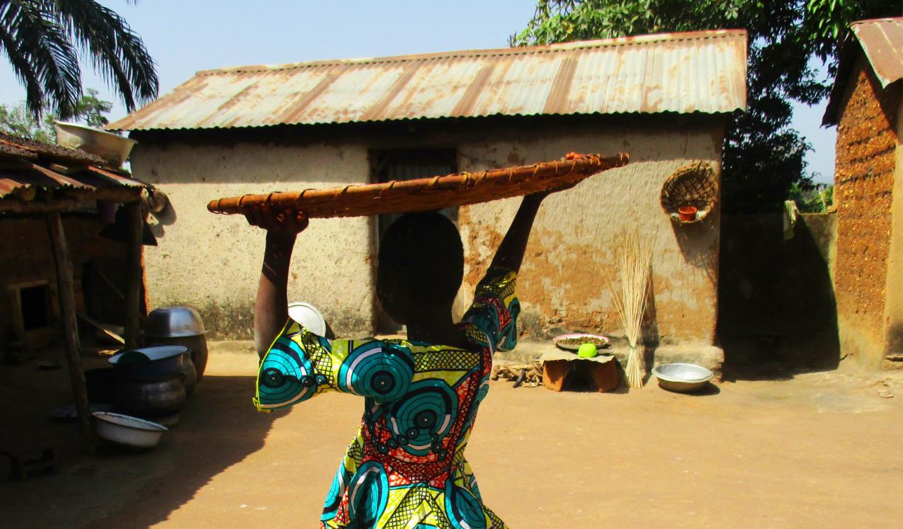 A lady carrying a large flat basket on her head. Credit: Plan International Togo
