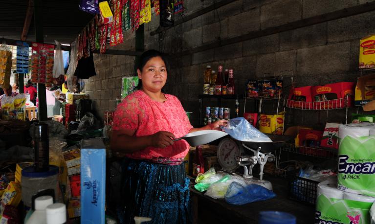 A woman attends her stall at a market in Guatemala City. © Maria Fleischmann / World Bank