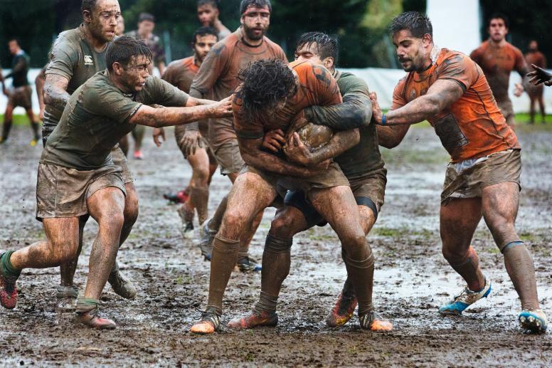 Men playing rugby in the mud. ©Quino Al/Unsplash