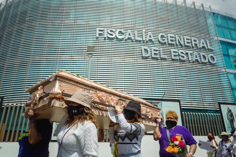Women carrying a coffin demonstrate on International Women's Day to demand justice for femicides in Mexico. © Alejandro_Munoz / Shutterstock ID: 2133896339