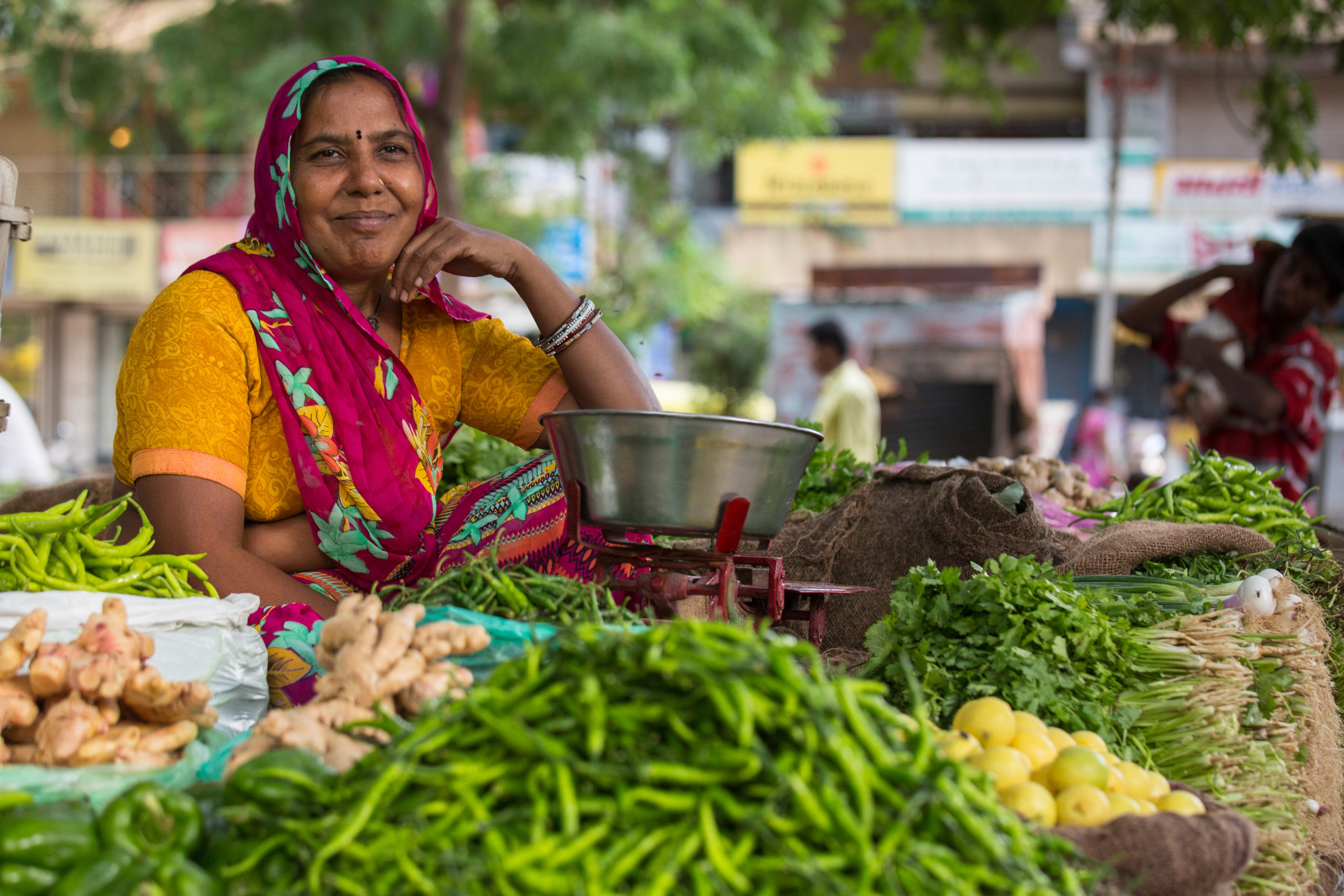 Choral Mauladia poses near by her cart where she sells vegetables at a local market.