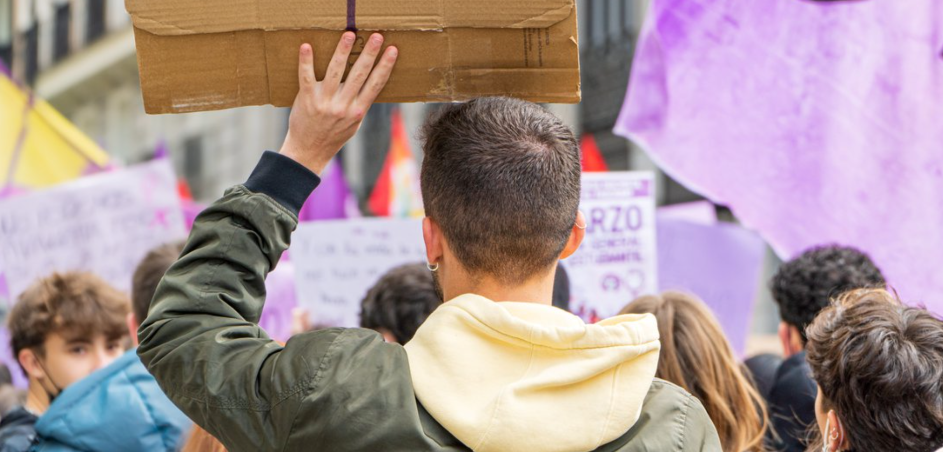 Young men attend an International Women's Day protest in the streets of Madrid, 8 March 2022. Credit: Komuso Colorsandia / Shutterstock.com