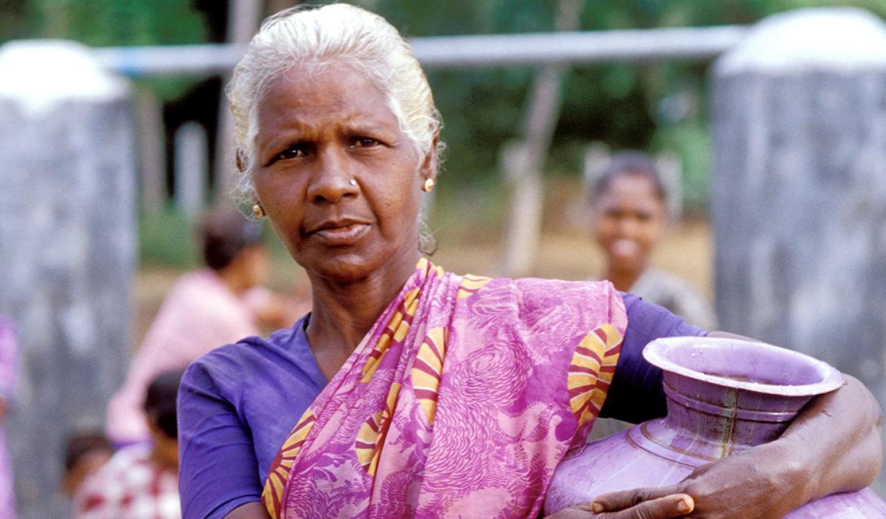 A woman with a water container at a well in Sri Lanka. Copyright: Dominic Sansoni / World Bank