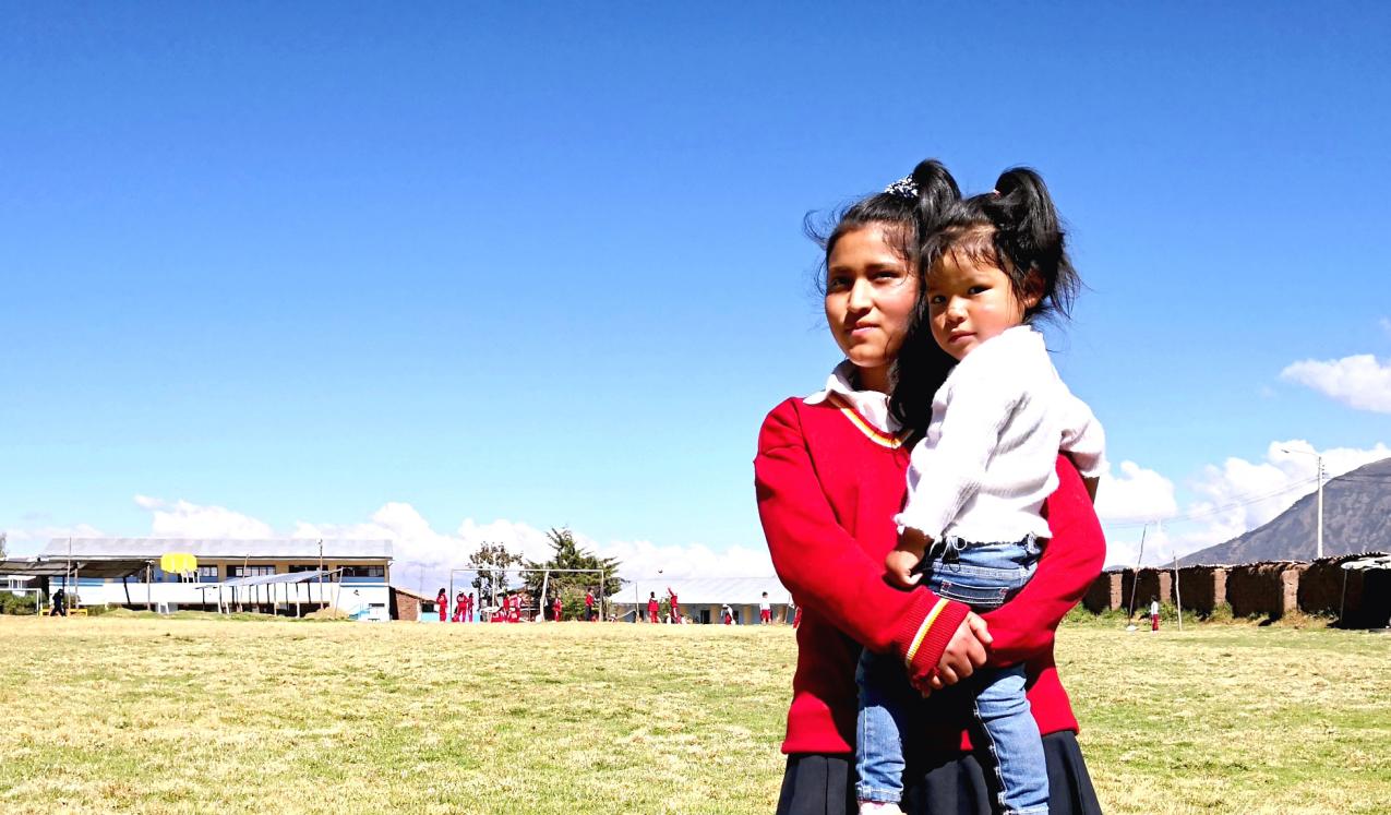 A schoolgirl holds her younger sister. Credit: Visionaria