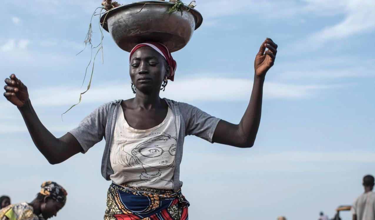 A woman distributes cassava cuttings while others plant them on on July 12, 2017 in Nigeria. © STEFAN HEUNIS/AFP/Getty Images