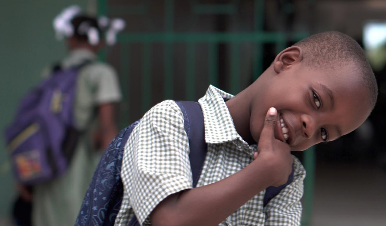 A school boy smiling for the camera. © Zach Vessels