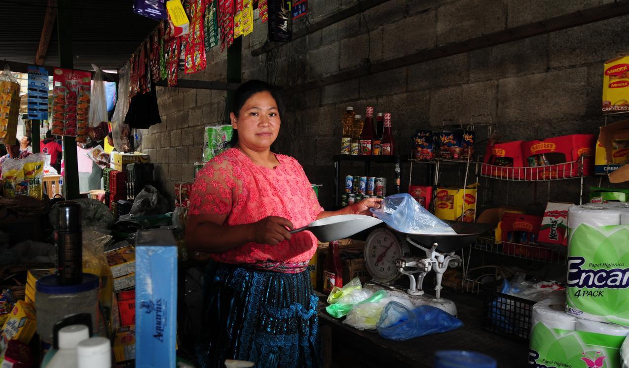 A woman attends her stall at a market in Guatemala City. © Maria Fleischmann / World Bank