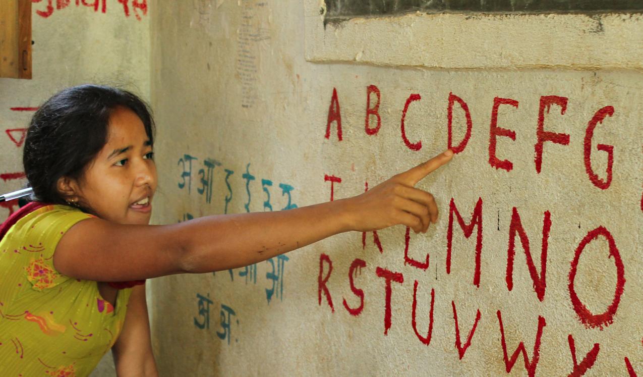 A teach in rural Nepal points to letters as she teaches her class how to read the English alphabet. © Aisha Faquir/World Bank