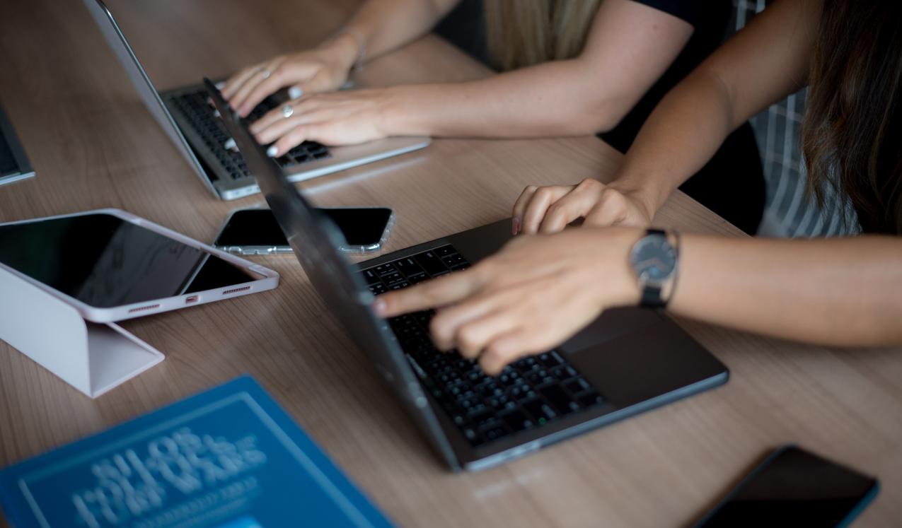 A close up of two laptops with hands working on them. © UN Women/Ploy Phutpheng/DSC_4884