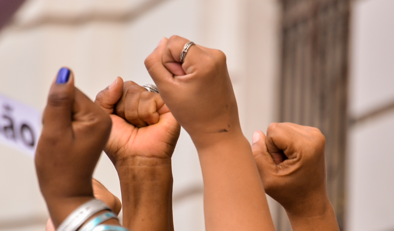 Feminist activists raise their hands at a march in Rio de Janeiro. Brazil, 2018. © Alexandre S. R. Horta | Shutterstock ID: 1195896610.