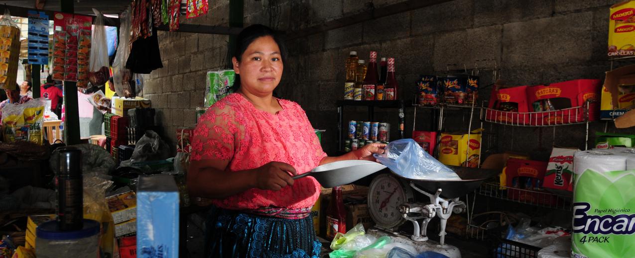 A woman attends her stall at a market in Guatemala City. © Maria Fleischmann / World Bank