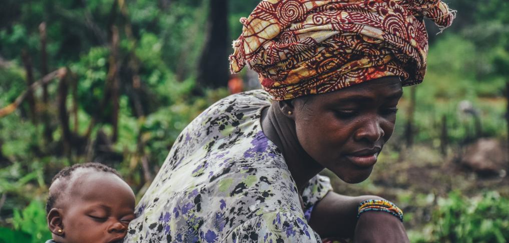 A woman with a baby on her back. Copyright: Annie Spratt