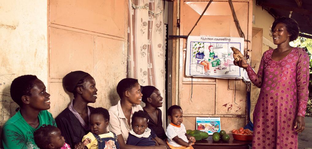 A community health promoter teaches mothers with small children about nutrition at her home hear Mityebili, Uganda. © Stephan Gladieu/World Bank