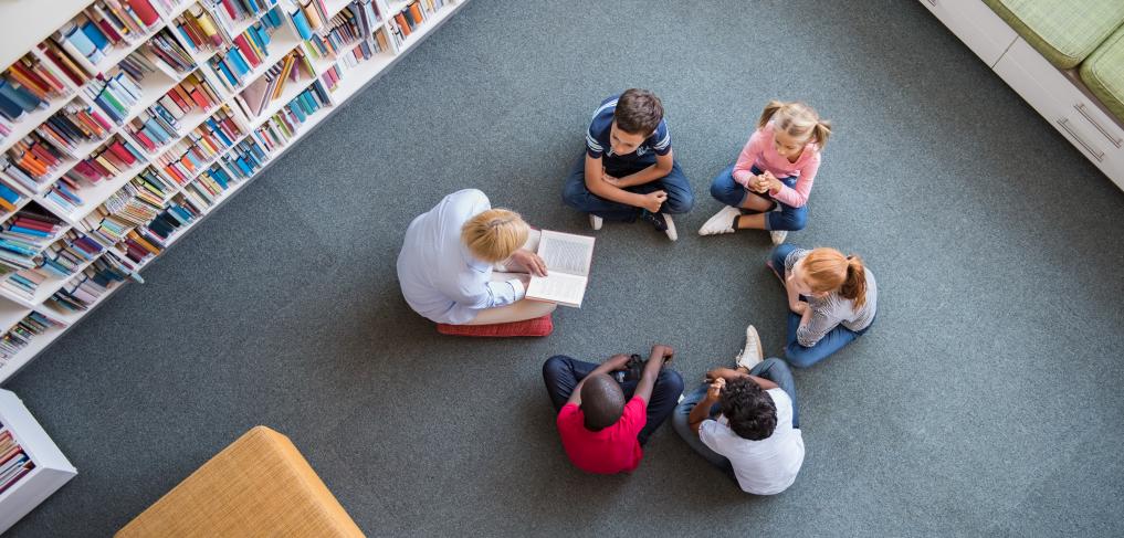 Teacher reading to children sitting in a circle in a library. © Ground Picture/Stock Photo ID: 1200999988