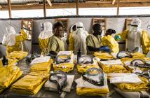 Health workers put on their personal protective equipment before treating people suspected of having Ebola at the Ebola Transition Center in the Democratic Republic of Congo. © World Bank/Vincent Tremeau