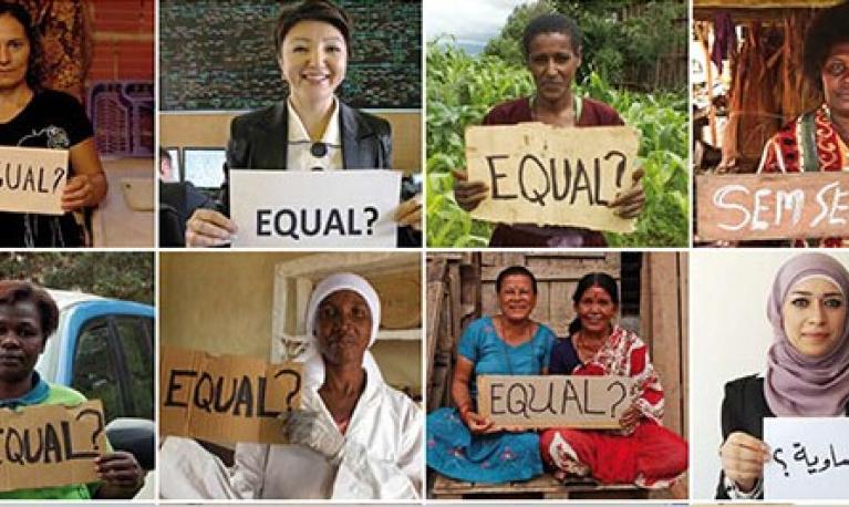 Women holding placards with the word EQUAL on them