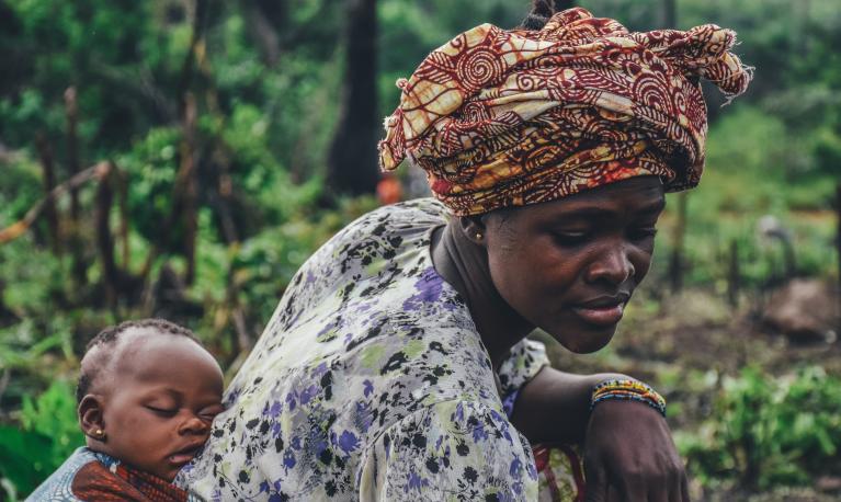 A woman with a baby on her back. Copyright: Annie Spratt