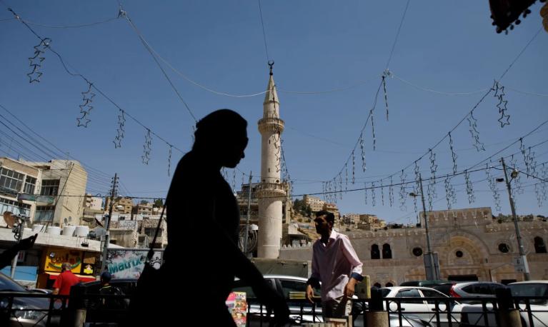 A women in silhouette walks through a square in Jordan. © Annie Sakkab/Bloomberg/Getty Images