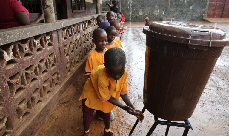 Students wash their hands before eating prepared meal at the Hope Kindergarten Elementary School in Tarbarr Community in Buchanan City, Liberia. © Dominic Chavez/World Bank