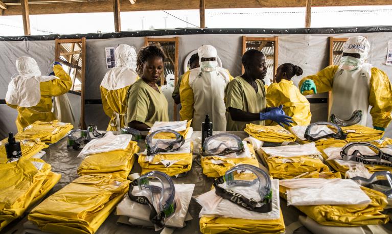 Health workers put on their personal protective equipment before treating people suspected of having Ebola at the Ebola Transition Center in the Democratic Republic of Congo. © World Bank/Vincent Tremeau