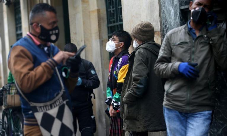 Angel Mendoza (C) and Martin Juco (2nd R), who are transgender and non-binary, stand in line outside a bank during gender-based quarantine restrictions, amidst the outbreak of the coronavirus disease (COVID-19) in Bogota, Colombia May 5, 2020. REUTERS/Luisa Gonzalez