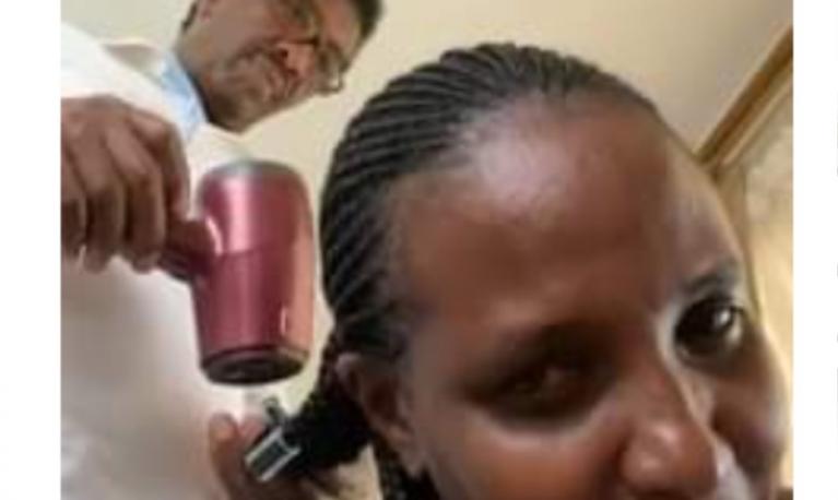 Former minister of Uganda styling his wife's hair ©watchdog.com