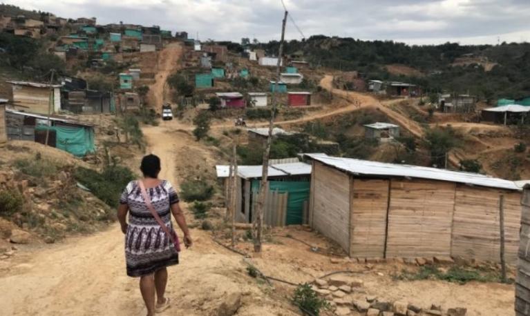 A woman walks on the outskirts of a makeshift suburb of a Colombian city, which is inhabited largely by returned Colombians and Venezuelans.