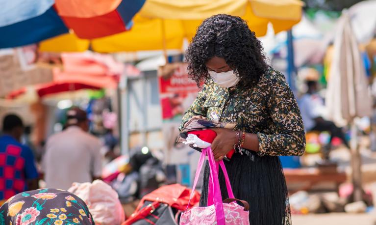 A woman wearing a mask at a marker ©shutterstock-1729753228