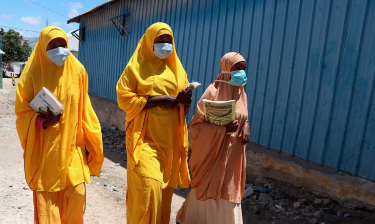 Students walk in a Mogadishu neighbourhood wearing face masks, Somalia. Photograph: Abdirazak Hussein Farah/AFP