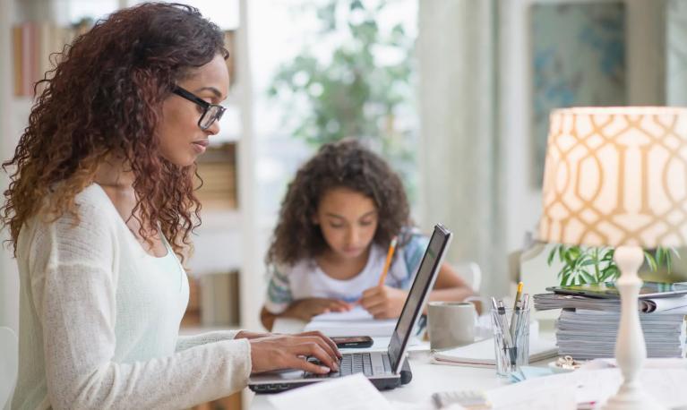 A mother and her daughter working at a table at home. Tetra Images/Getty Images/Tetra images RF