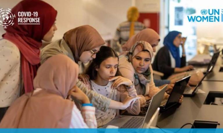 Women gathered round a computer © UN Women