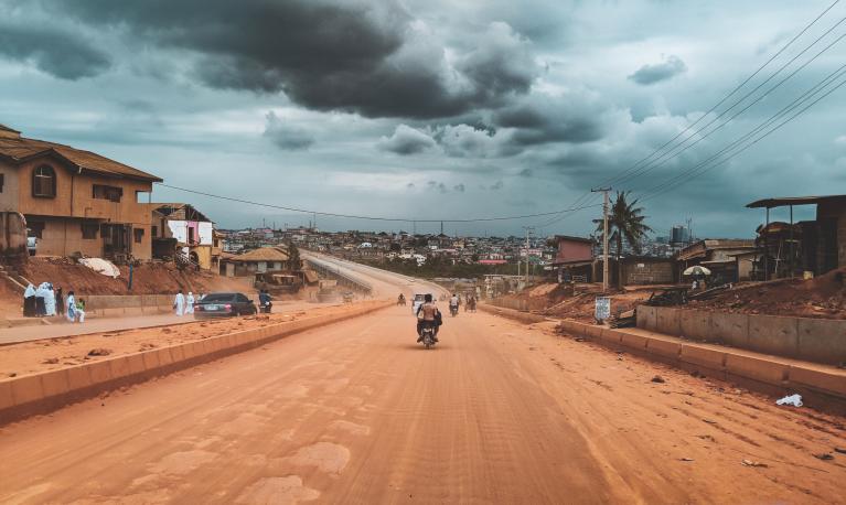 Dirt road in Nigeria with fellow commuters and community members.