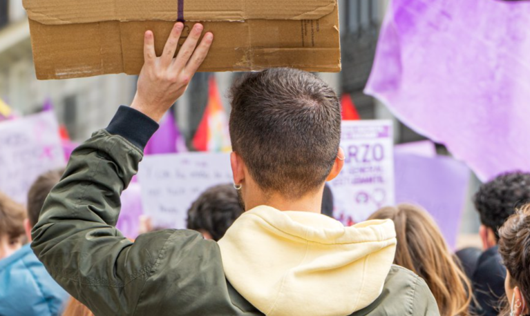 Young men attend an International Women's Day protest in the streets of Madrid, 8 March 2022. Credit: Komuso Colorsandia / Shutterstock.com