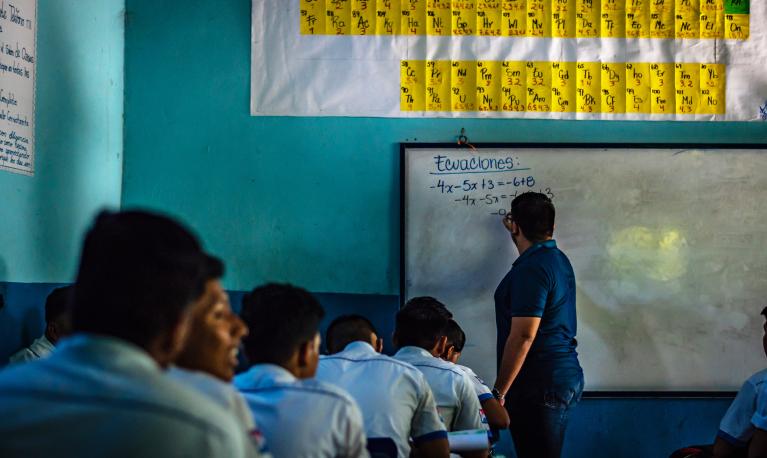 A teacher guiding students in a classroom at a Guatemalan college in Guazacapan. © ShutterPrice | Shutterstock ID: 1223048206