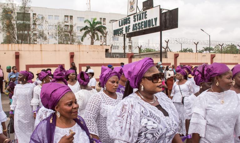 Women wearing purple and white outfits at a protest rally in response to the government's rejection of a gender equality bill.  Lagos, Nigeria, March 2022. © Tolu Owoeye | Shutterstock ID: 2150255357