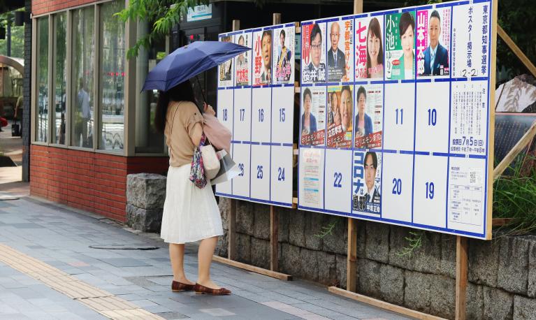 A woman looks at candidate posters for Tokyo’s Governor election, Japan, 2020. © Ned Snowman | Shutterstock