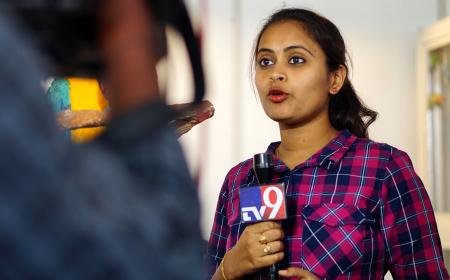 Female TV reporter covering live news in Hyderabad, India. Credit: Reddees / Shutterstock.com
