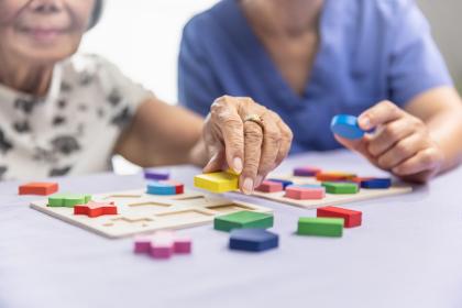 Caregiver and senior woman working on shape puzzles for dementia prevention © Toa55 | Shutterstock.com