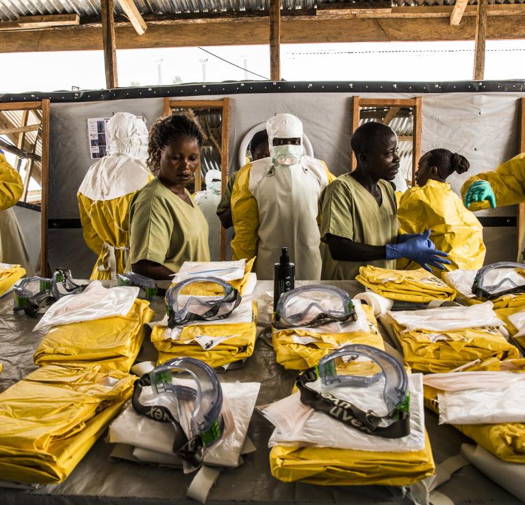 Health workers put on their personal protective equipment before treating people suspected of having Ebola at the Ebola Transition Center in the Democratic Republic of Congo. © World Bank/Vincent Tremeau