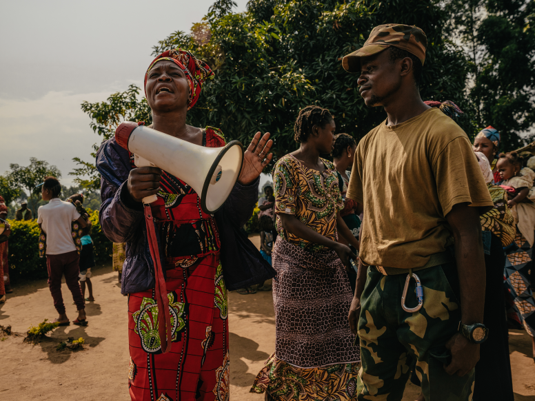 A woman speaks while a soldier looks on during a dialogue event between local women and the families of a Congolese Army commando unit stationed at a garrison nearby. Beni, North Kivu Province, Democratic Republic of Congo, July 2022. Credit: Hugh Kinsella Cunningham